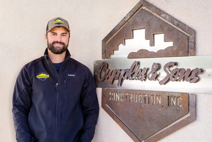 Casey Cupples beside the steel Cupples and Sons sign